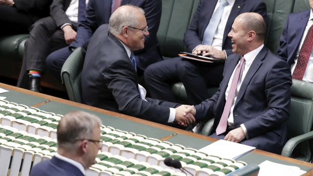 Prime Minister Scott Morrison and Treasurer Josh Frydenberg shake hands after their income tax bill passed the House of Representatives.