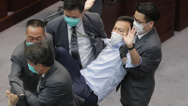 Pan-democratic legislator Raymond Chan Chi-chuen is taken away by security guards during a Legislative Council's House Committee meeting, in Hong Kong.