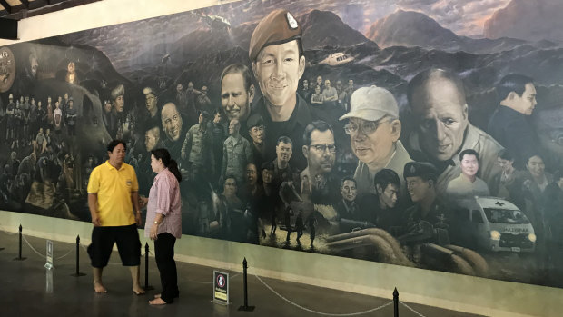 Tourists in front of a mural inside the new visitor centre at Tham Luang Cave. 