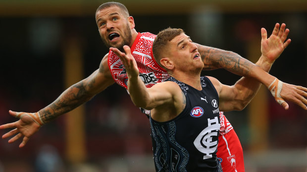 Lance Franklin battles Jacob Weitering of the Blues for possession. 
