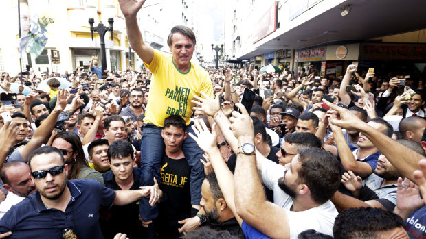 Jair Bolsonaro is taken on the shoulders of a supporter moments before being stabbed during a campaign rally in Juiz de Fora, Brazil.
