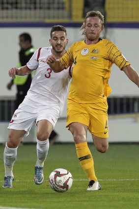 Defender Ryan Grant duels for the ball with Syria's defender Mouaiad Al Ajjan.