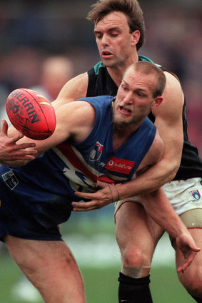 Pedigree: Kyle's father, Port Adelaide's Brett Chalmers (rear), loses out to the Bulldogs' Danny Southern at Optus Oval in 1999.
