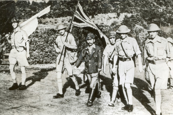 Staff Officer Sugita conducts Lieutenant General Arthur Percival (right) and other British officers to the Ford factory at Bukit Timah, where the surrender took place. 
