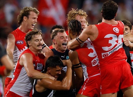 Carlton and Sydney players wrestle during the match at the SCG.