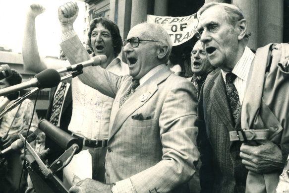 Donald Horne, centre, with union leader John Halfpenny, left, and authors Patrick White (right) and Frank Hardy in the background, leading the singing of Advance Australia Fair at Sydney Town Hall in 1976. They were “maintaining the rage” over the dismissal of prime minister Gough Whitlam one year earlier.