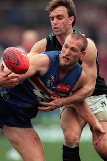Pedigree: Kyle's father, Port Adelaide's Brett Chalmers (rear), loses out to the Bulldogs' Danny Southern at Optus Oval in 1999.