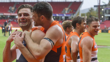 Please stay, mate: Sam Reid embraces Stephen Coniglio after the midfield gun starred in the Giants' big round-one win over Essendon.