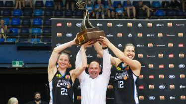 Kelsey Griffin, coach Paul Goriss and Marianna Tolo hold the grand final trophy.