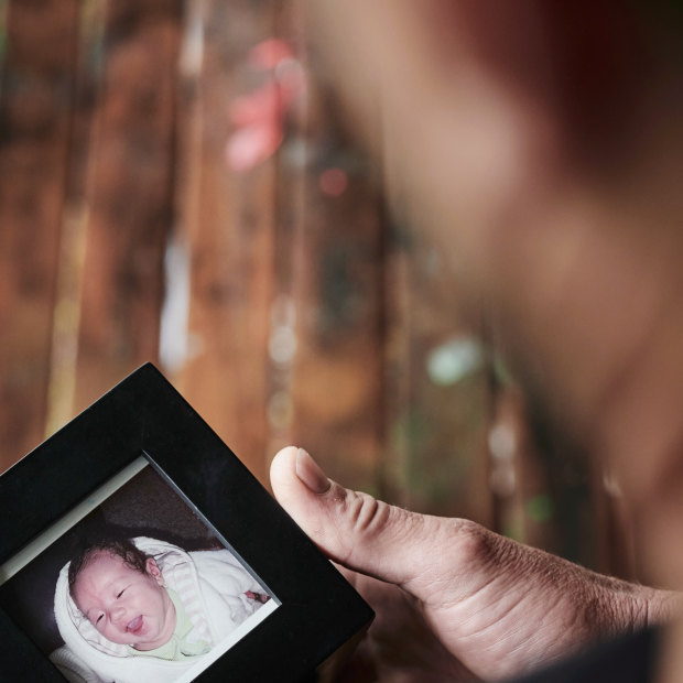 Daniel Wass looks at a photo of his son Sean who was abducted by his mother when he was a toddler. 