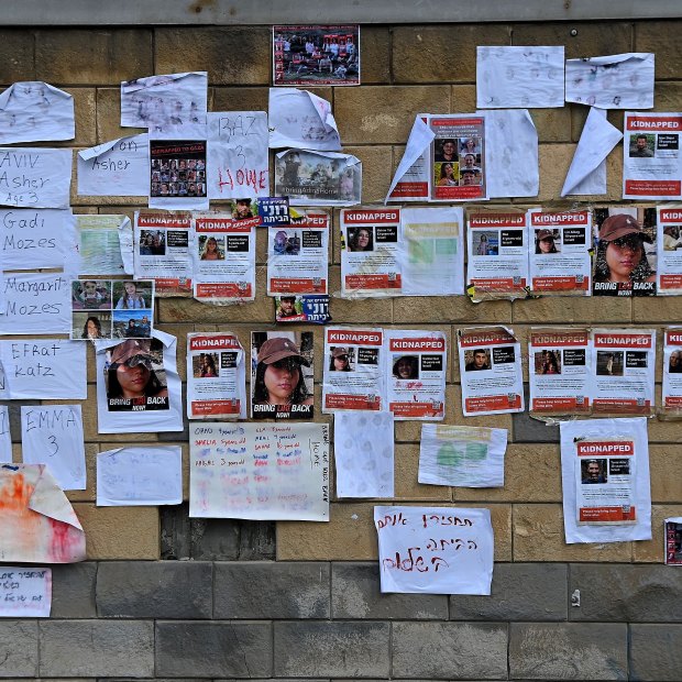 Posters of the faces of Israeli hostages taken by Hamas on October 7 and signs on a wall in Tel Aviv, Israel.