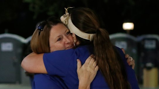 Volunteers Denise Buessing, left, and Marsha Struzik embraces following a deadly shooting at the Gilroy Garlic food festival in California on Sunday.