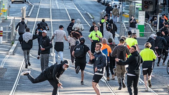 Anti-mandatory vaccine and lockdown protesters run from police in Melbourne yesterday. 
