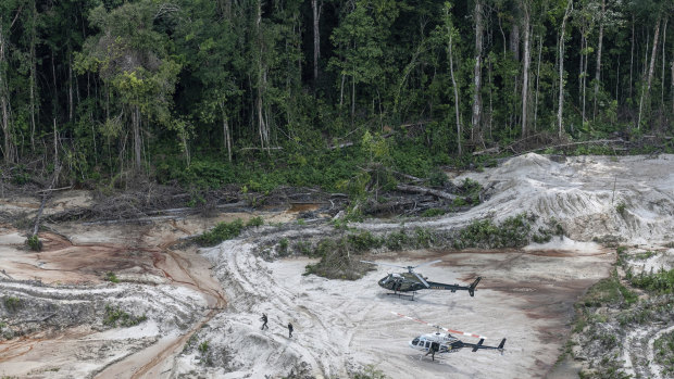 Ibama inspectors walk through an area affected by illegal mining after landing in Munduruku indigenous lands in Para state in Brazil's Amazon basin. 