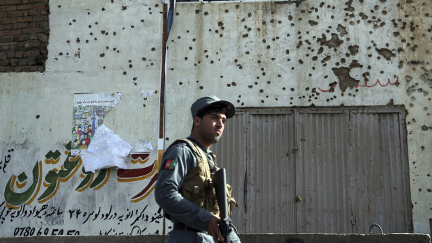 An Afghan security officer inspects the site of suicide attack near the election commission office in Kabul in October. 