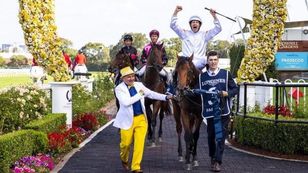 Hugh Bowman raises his arms in celebration after piloting Farnan to victory in the Golden Slipper on Saturday.