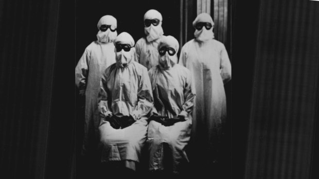 Group portrait of medical workers in protective gear during 1919 influenza epidemic.