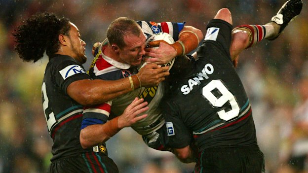 Craig Fitzgibbon is tackled by Luke Priddis and Tony Puletua.