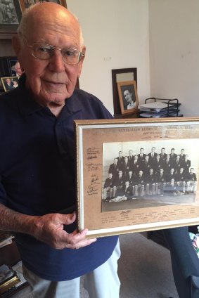 Eric Tweedale holding a photo of the 1946 Australia team.
