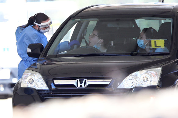 People are tested for COVID-19 at a testing clinic in Indooroopilly State High school.
