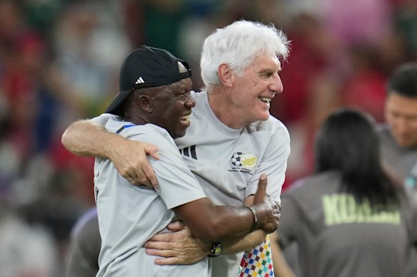South Africa head coach Hugo Broos, right, celebrates with his team.