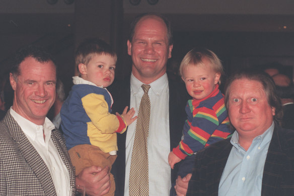 Doug Mulray with Peter FitzSimons (holding sons Jake and Louis) and Mike Carlton at a book launch in the 1990s.