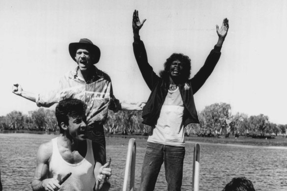  Midnight Oil's Peter Garrett and Rob Hirst with the Warumpi Band's George Rrurrambu (deceased)  performing at Yellow Water (Ngurrungurrudjba) on the South Alligator River at Kakadu during Blackfella/Whitefella Tour in 1986.
