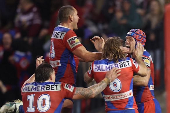 The Knights celebrate after Kalyn Ponga’s winning try.