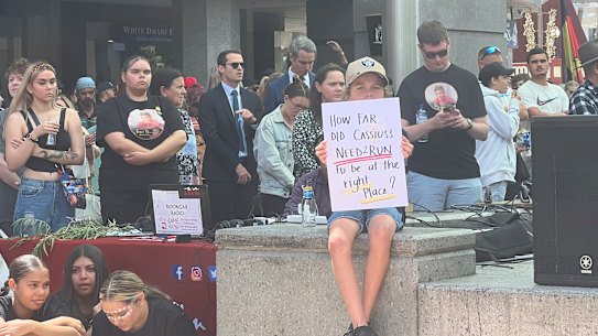 A young boy at the rally for Cassius Turvey in Perth, with a sign that reads ‘how far did Cassius need 2 run to be at the right place?’