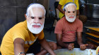 Mumbai sweet-makers wear masks of Prime Minister Narendra Modi ahead of the election results.