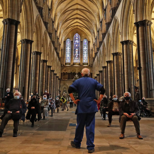 A medic monitors people who sit and wait after receiving their vaccine at Salisbury Cathedral. 