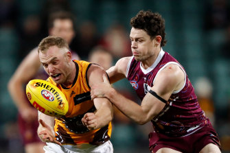 Tom Mitchell is tackled by Lachie Neale in Hawthorn’s win over the Lions.