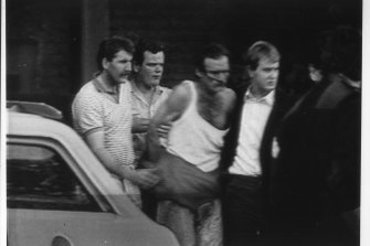 Russell Cox (in singlet) during his arrest in 1988.