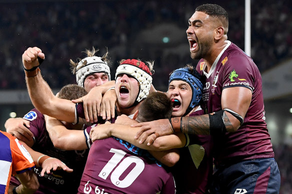 James O’Connor is swamped by teammates after scoring late to seal the title for the Reds last season.