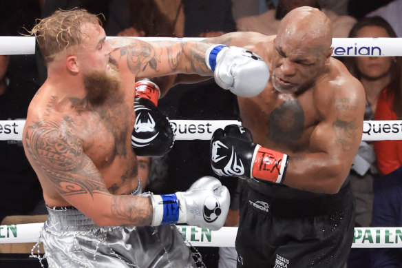 Boxer Jake Paul receives a punch from Mike Tyson during their heavyweight bout at AT&T Stadium in Arlington, Texas.