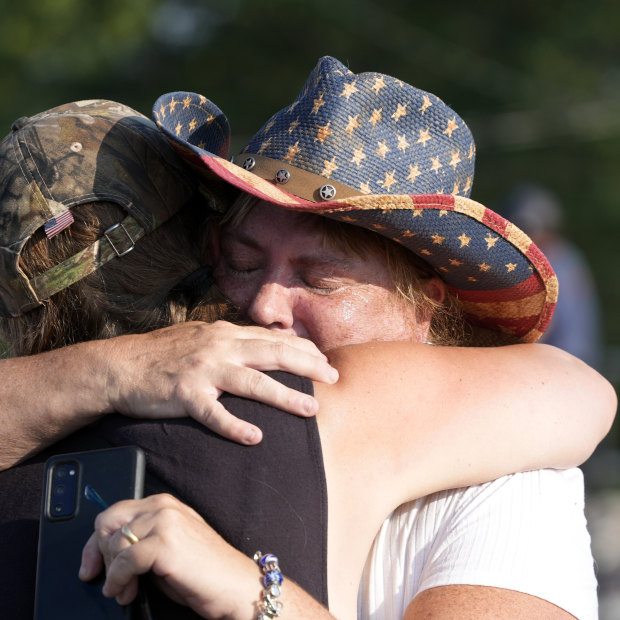 People hug after Donald Trump was taken away from the event.