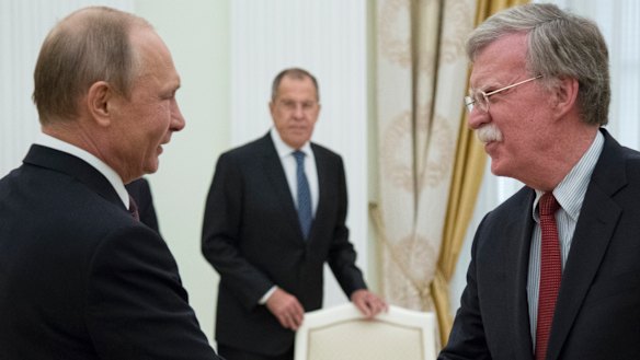 Russian President Vladimir Putin and US National Security Adviser John Bolton greet each other in Moscow last week.