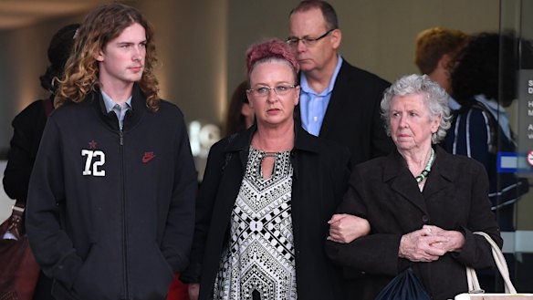 Manslaughter victim Darren Pullar's partner Collette Dunn (centre) and his son Aidan (left) leave the Supreme Court in Brisbane on Friday.