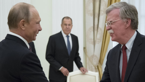 Russian President Vladimir Putin and US National Security Adviser John Bolton greet each other in Moscow last week.
