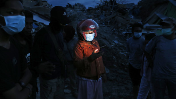 A woman uses her mobile phone in Petobo neighbourhood, which was wiped out by earthquake-triggered liquefaction in Palu.