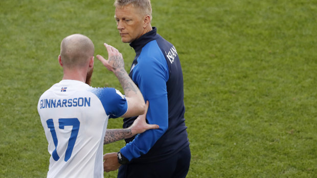 Cool as ice: Iceland's Aron Gunnarsson grabs the arm of coach Heimar Hallgrimsson.