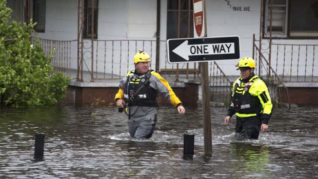 Members of the Greenville Fire Department swift water team go house to house checking flooded homes following Florence on Saturday.