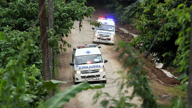 Ambulances carrying the 10th and 11th rescued drive away from Luang cave.