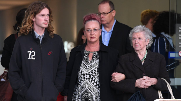 Manslaughter victim Darren Pullar's partner Collette Dunn (centre) and his son Aidan (left) leave the Supreme Court in Brisbane on Friday.
