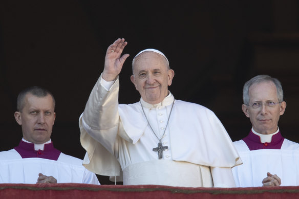 Pope Francis waves to the crowd after delivering the Christmas day blessing.