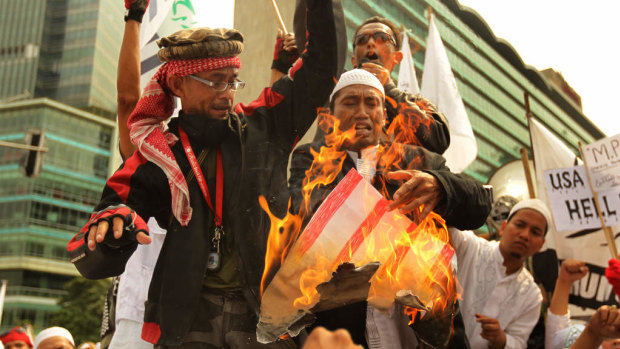 Protesters from Indonesia's hardline Islamic Defenders Front burn a poster of a US flag in 2012 to protest against the movie <i>Innocence of Muslims</i>.