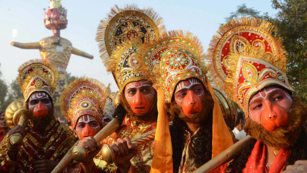 Hindus dressed as  Lord Hanuman pose during a religious procession.