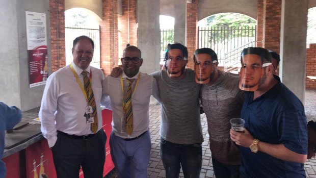 Cricket South Africa executives Clive Eksteen and Altaaf Kazi pose with fans in Williams masks on Friday.
