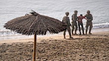 Spanish army soldiers assist a migrant who swam from Morocco to the Spanish enclave of Ceuta.