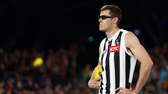 Mason Cox of the Magpies looks on.